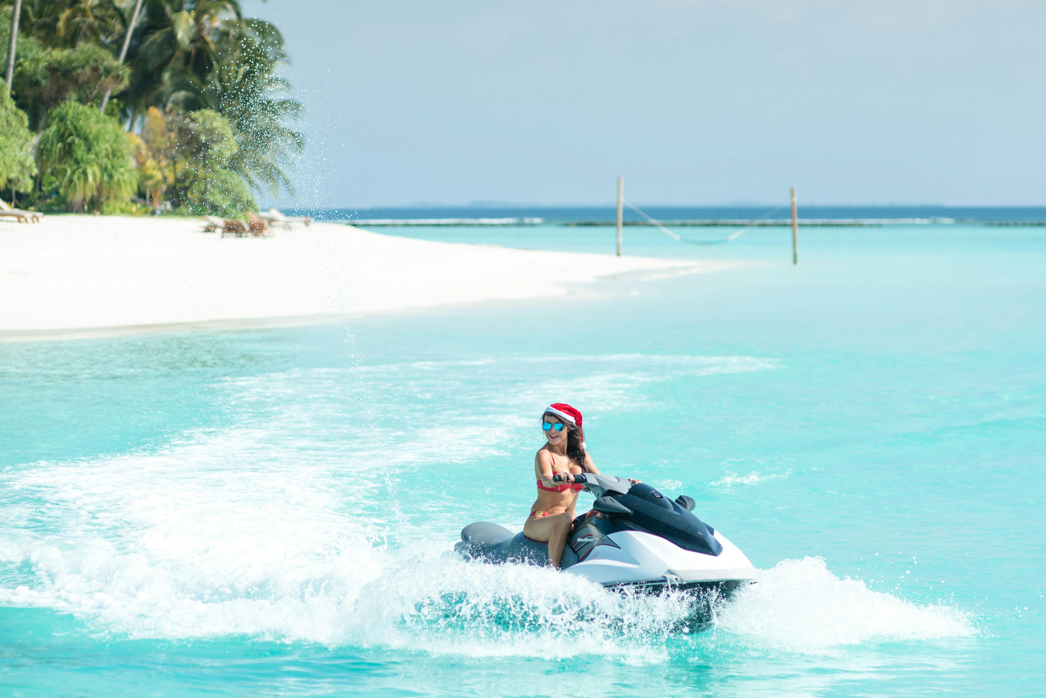 Prescription Goggle Inserts - Woman on a jet ski in the Maldives, enjoying a sunny day and turquoise waters.