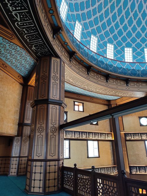 Free Detailed view of a mosque's interior featuring ornately decorated columns and a dome. Stock Photo