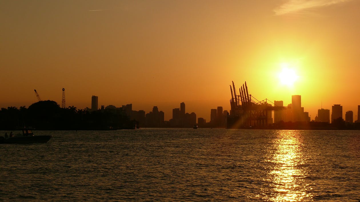 Silhouette of Buildings Near Body of Water Under Golden Hour