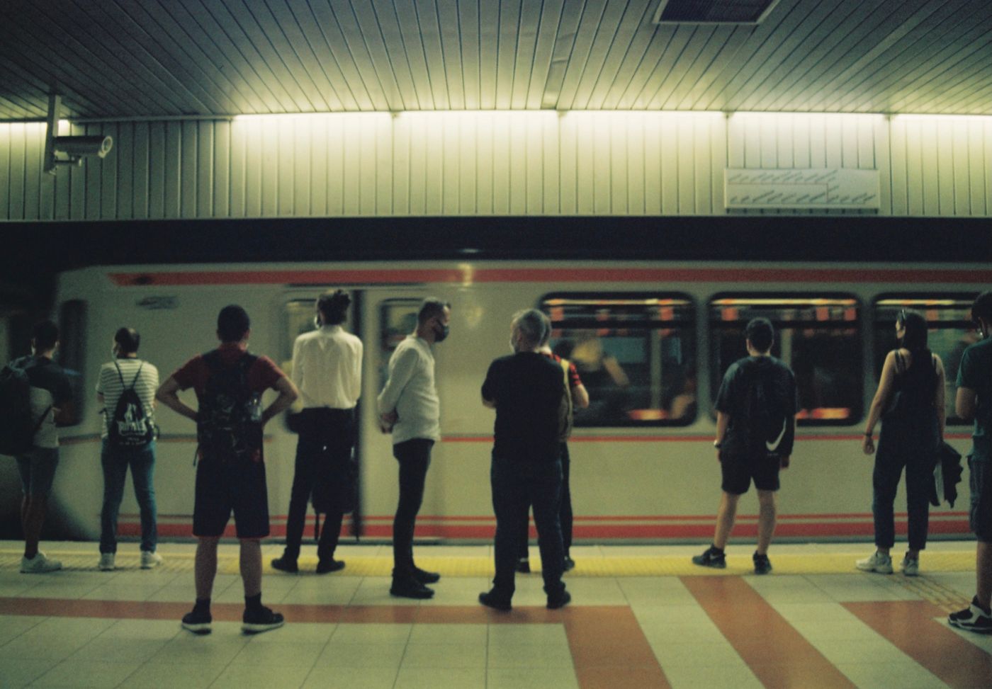 Commuters on a subway platform as a train arrives