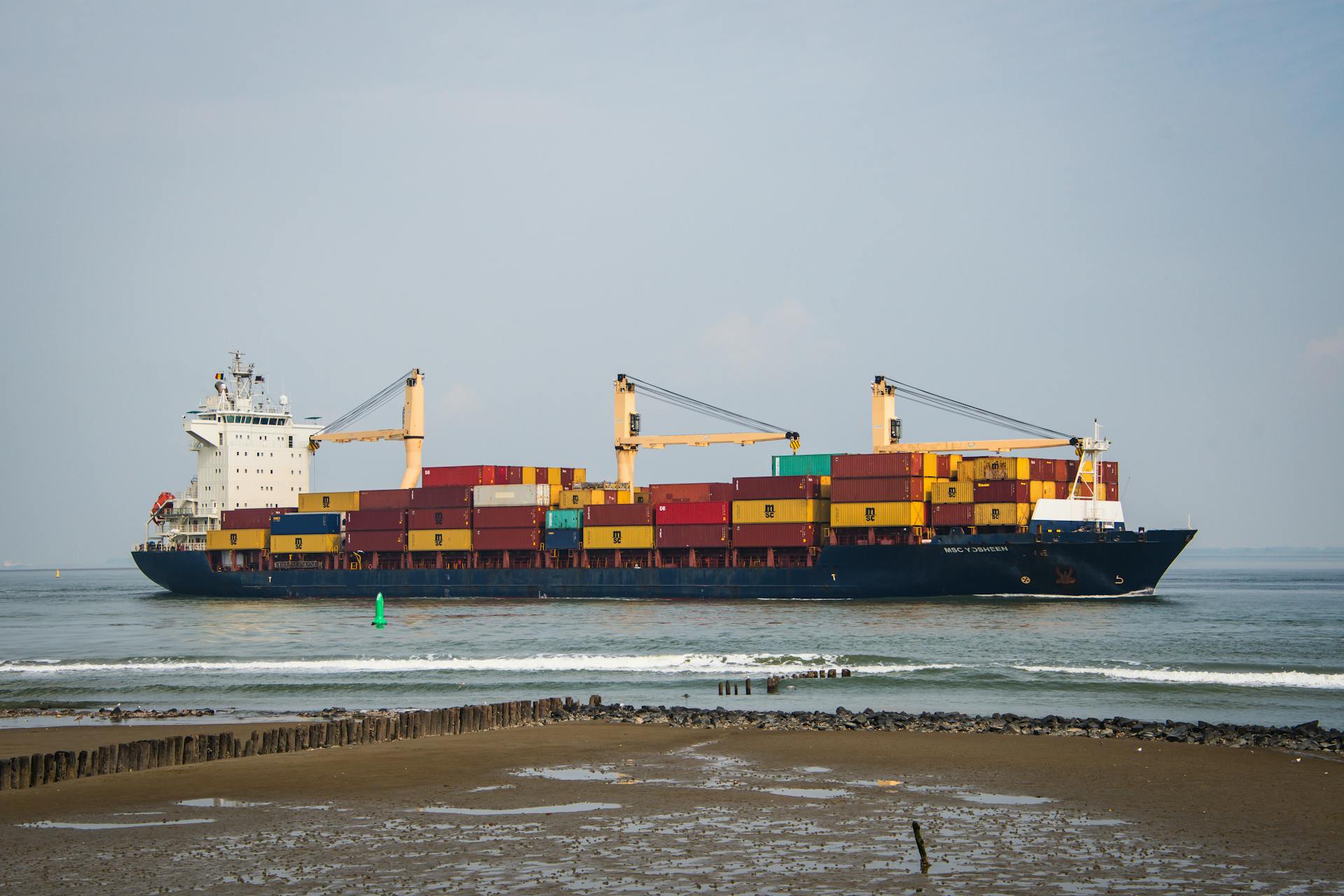 Cargo ship carrying colorful containers sails near Terneuzen, Netherlands
