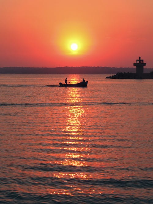 Silhouette of a Boat on the Sea during Sunset