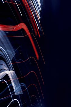 Abstract long exposure light trails on a dark background, creating a dramatic effect.