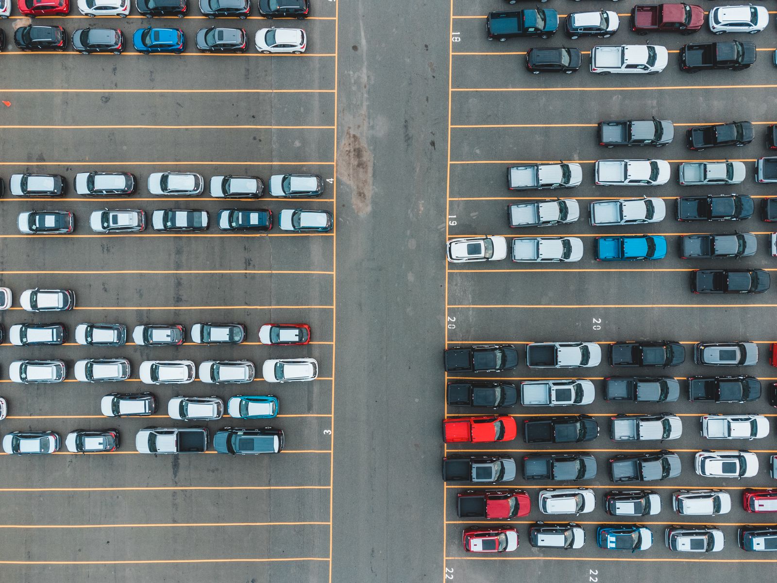 Wide aerial view of a large vehicle lot showing organised rows of cars