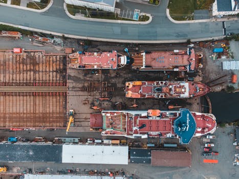 Drone shot of shipyard showcasing docked vessels and heavy machinery from above.