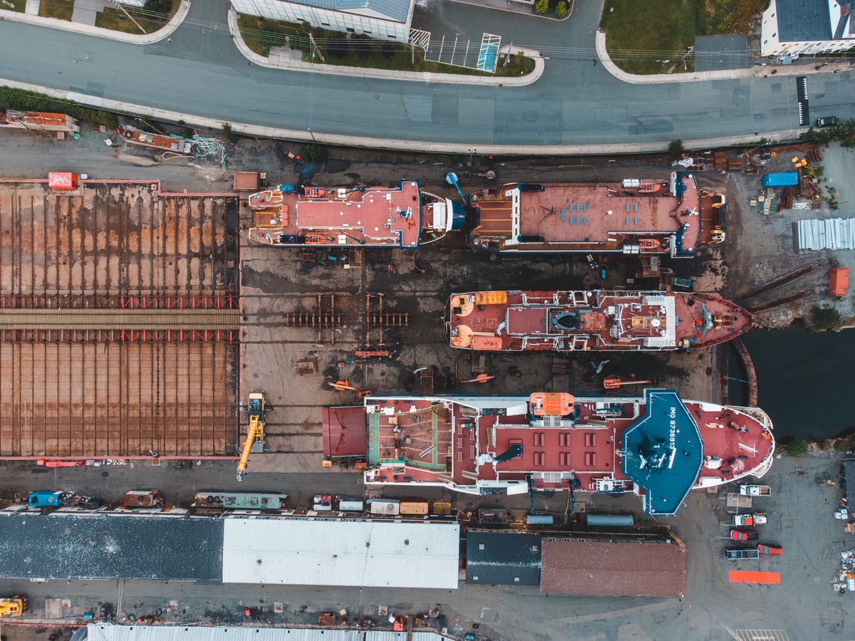Aerial drone view of a shipyard with docked vessels and heavy machinery, similar to Hendry Marine Industries' Port of Tampa facility