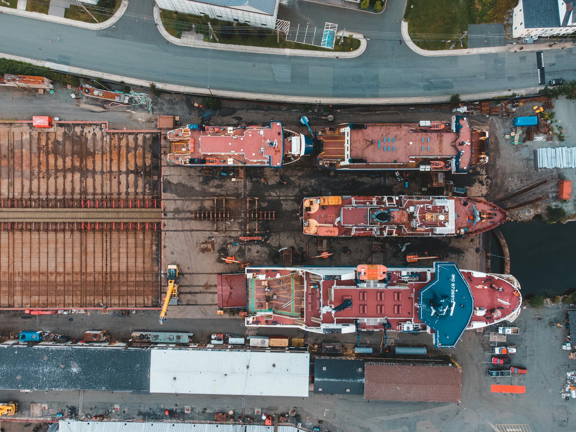 Drone shot of shipyard showcasing docked vessels and heavy machinery from above.