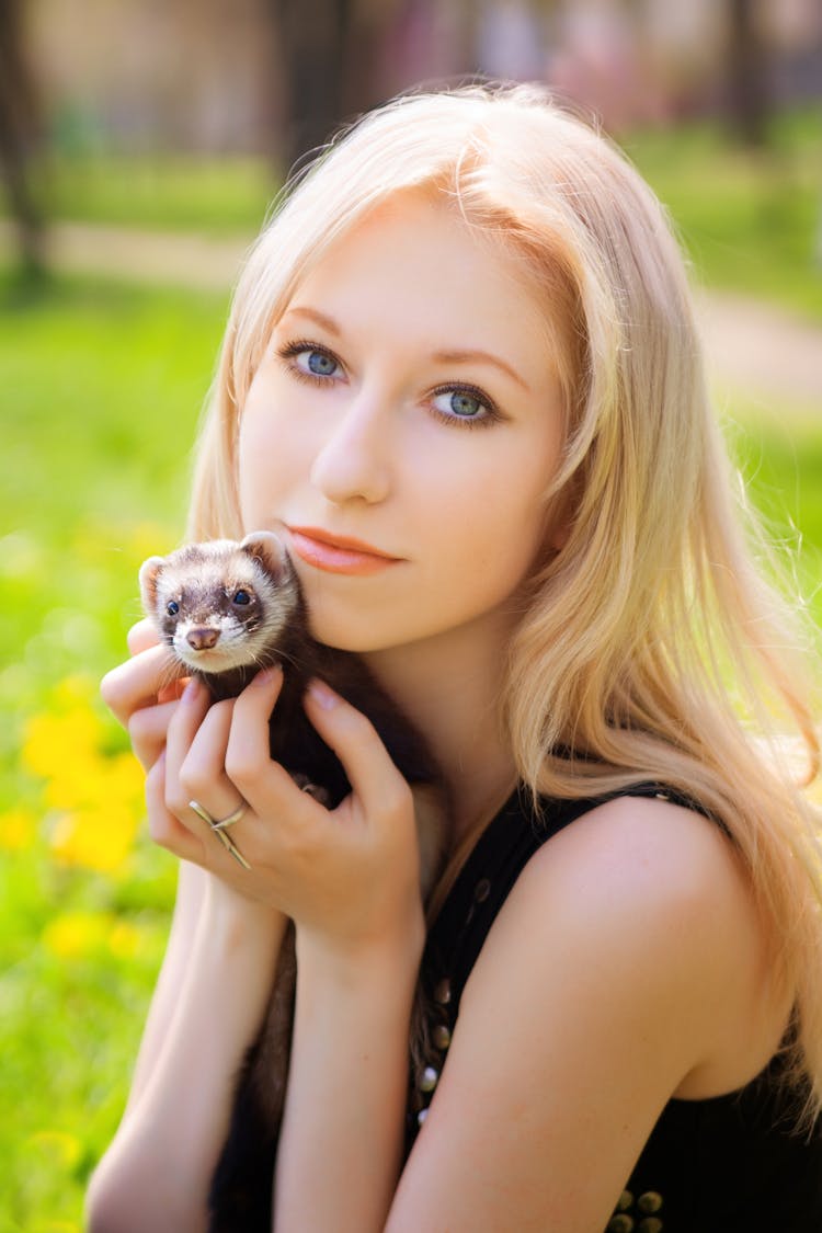 A Woman Holding A Ferret 