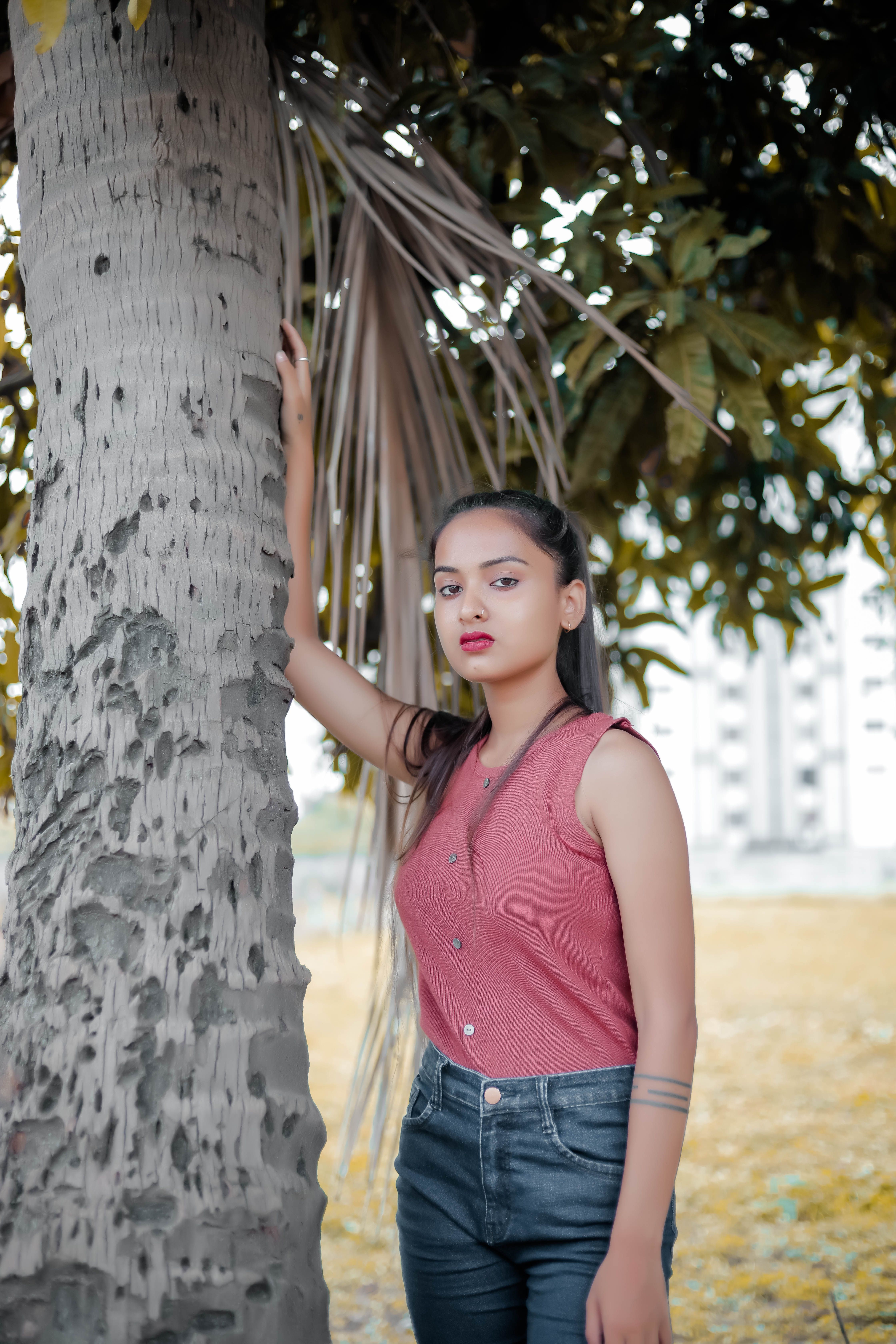 Woman Standing Beside Tree Trunk · Free Stock Photo
