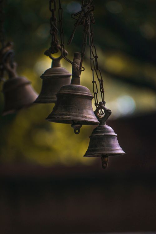 Free Selective focus on rustic hanging bells with blurred background outdoors. Stock Photo
