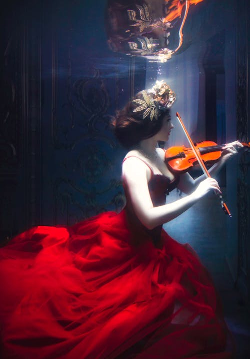 A Woman Playing a Violin Underwater