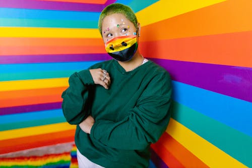 Free 
A Woman with Face Stickers Wearing a Sweater in a Colorful Room Stock Photo