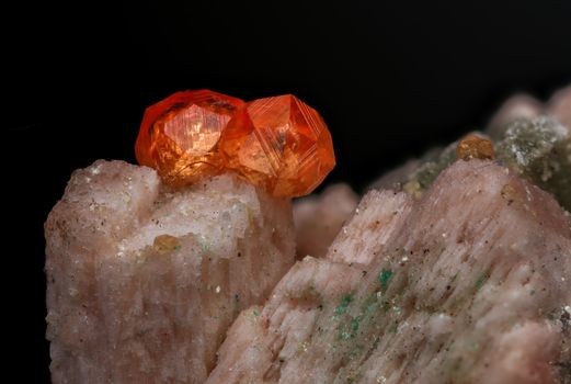 Detailed close-up of vibrant red crystals on a mineral rock background.
