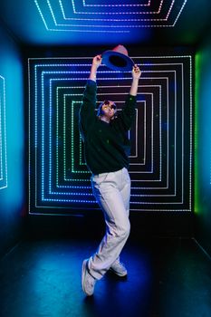 A person joyfully dances under colorful neon lights, creating a dynamic and vibrant atmosphere.