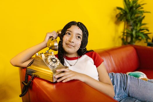 Woman in White Shirt and Blue Denim Jeans Sitting on Red Couch