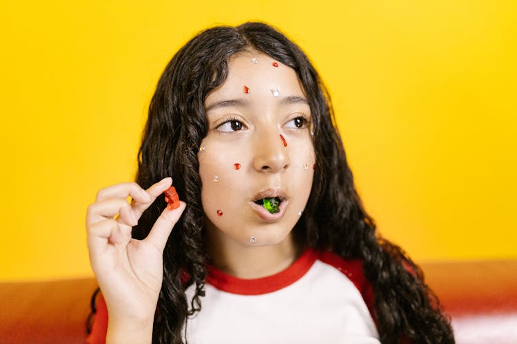 Woman In Red And White Shirt Eating Green Gummy Bears