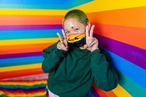 Woman in Black Sweater Wearing Rainbow Face Mask