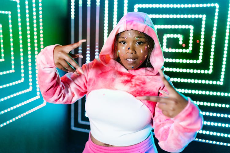 Woman In Pink Hoodie Standing Near The Neon Lights