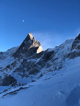 黎明时分，晴朗的蓝天下，白雪皑皑的山峰构成了一幅令人叹为观止的冬日景色