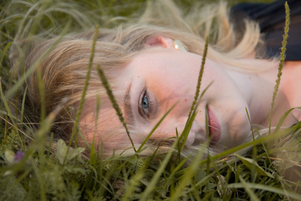 Person resting in long meadow grass — photo by Christina Chekhomova on Pexels