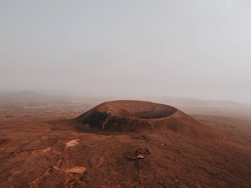 Stunning aerial view of Calderon Hondo volcano amidst a foggy, arid landscape in Spain.