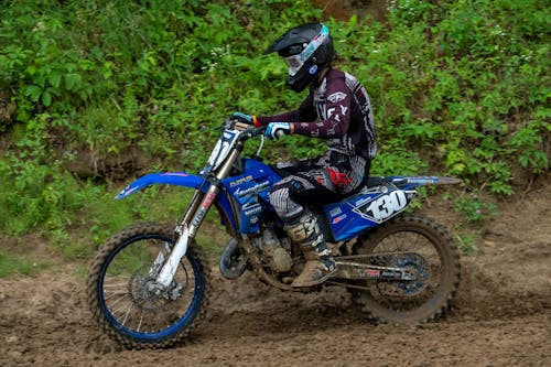 Free Man riding a Motocross on Muddy Dirt Road Stock Photo