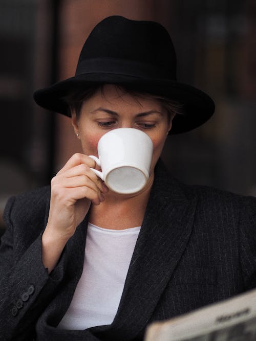 A Woman in Dark Gray Blazer Drinking Coffee