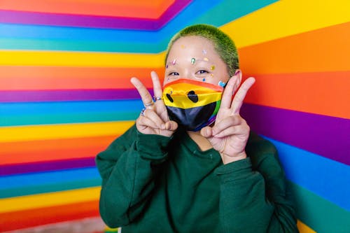 Woman against Rainbow Showing V sign