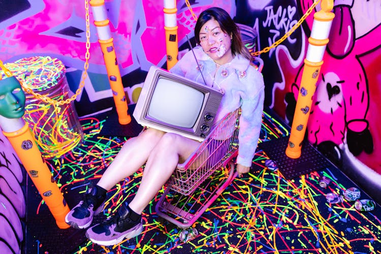 Photo Of A Woman With A Television Sitting On A Shopping Cart