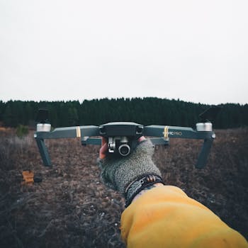 Close-up of a person holding a Mavic Pro drone in a scenic outdoor setting.