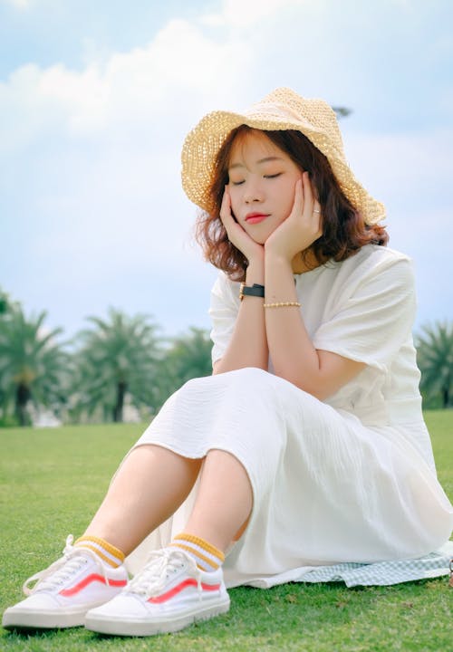 A Woman in White Dress Wearing Brown Sun Hat
