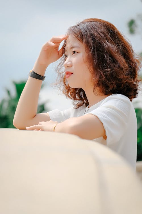 Free A Woman in White Shirt with Her Hand on Her Head Stock Photo