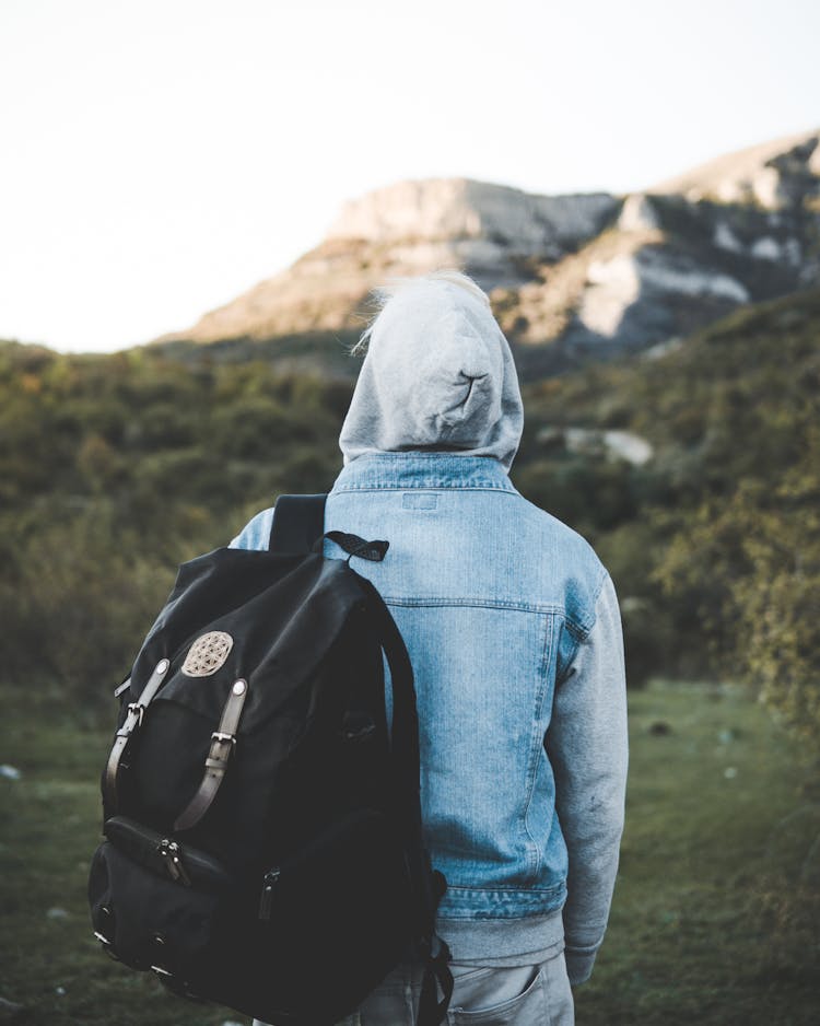 A Person In Denim Jacket Carrying A Backpack