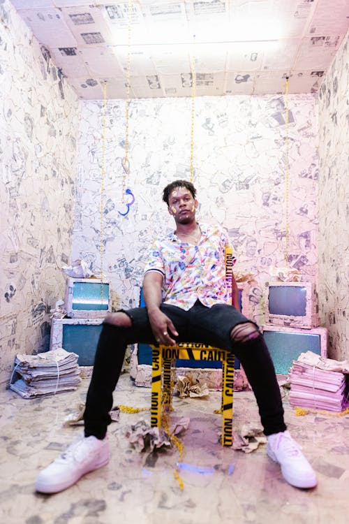 Free Man Sitting on Chair in Newspaper Room Stock Photo