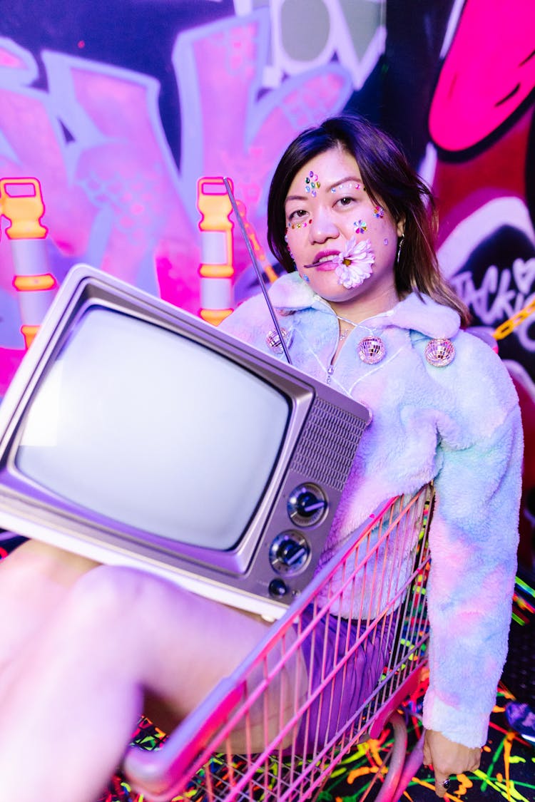 Woman Sitting In A Shopping Cart Holding A Television