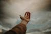 Free Person's Hand Reaching Out to the Sky Stock Photo