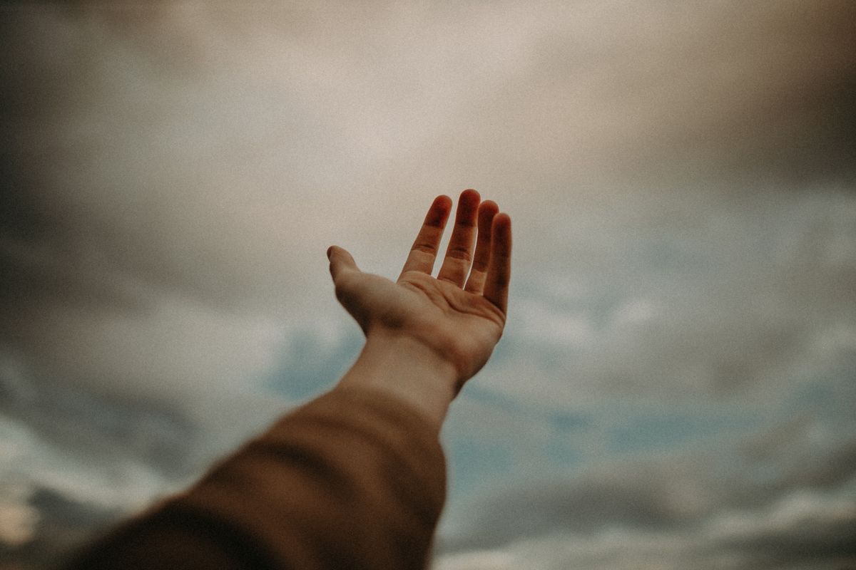 Person sticking hand out as a sign of hope