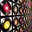 墙上框着五颜六色的黑胶唱片，展现出复古音乐主题