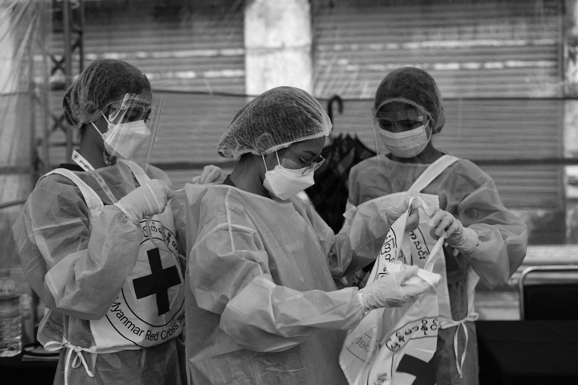 Healthcare workers in PPE organize supplies during a safety drill outdoors.