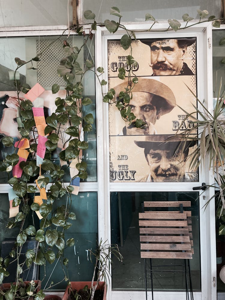 
Vines Crawling On A Glass Door With A Vintage Poster