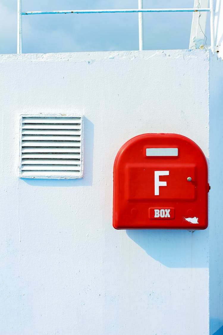 A Red Mailbox On White Wall