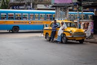 Two Men Leaning on Yellow Car while Talking