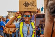 Girl in Yellow and Blue Crew Neck T-shirt Wearing Blue Sunglasses Holding Brown Cardboard Box