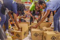 Woman in Blue T-shirt and Brown Pants Holding Brown Cardboard Box