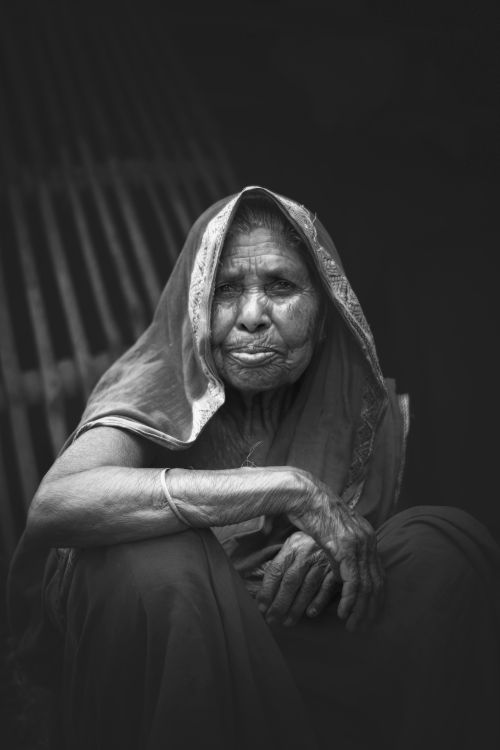Free A striking black-and-white portrait of an elderly woman from Bangladesh, capturing her expressive gaze. Stock Photo