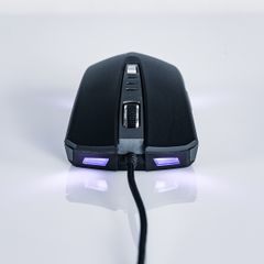 Black wired gaming mouse with purple lights on a white surface