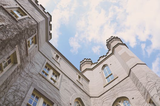 Upward view of a Gothic building with ivy-covered walls against a blue sky in London, Ontario.