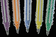 气泡环绕的彩色铅笔特写生动鲜明，背景为对比强烈的黑色