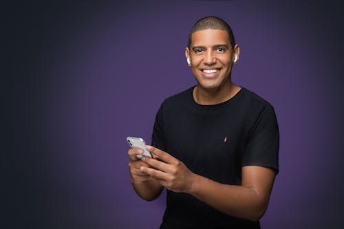 
A Man in a Black Shirt Using His Smartphone