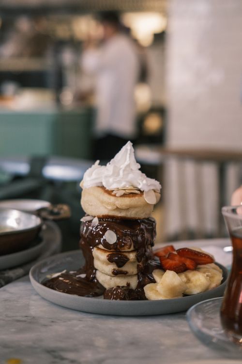 Free Indulgent pancake stack topped with chocolate sauce, whipped cream, and fresh fruit, perfect for dessert lovers. Stock Photo